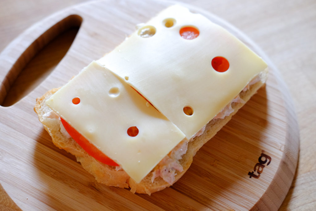 パンにツナ、トマト、チーズを乗せる